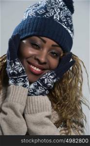 Portrait of african woman on gray background wearing woolen accessories