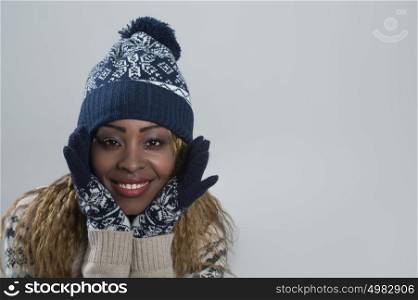 Portrait of african woman on gray background wearing woolen accessories
