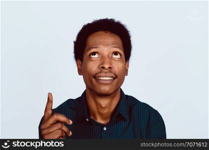 Portrait of Afro American man pointing up on studio.