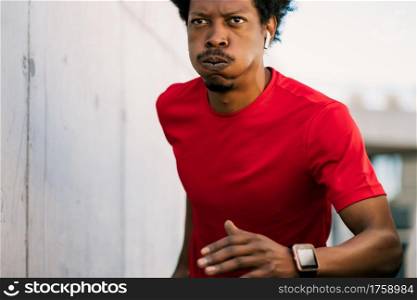 Portrait of afro athlete man running and doing exercise outdoors. Sport and healthy lifestyle.