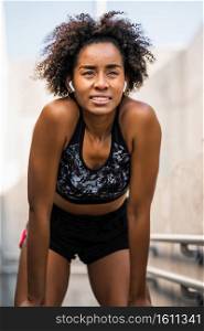 Portrait of afro athlete woman relaxing after work out outdoors. Sport and healthy lifestyle.. Athlete woman relaxing after work out outdoors.