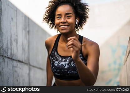 Portrait of afro athlete woman running and doing exercise outdoors. Sport and healthy lifestyle.. Afro athlete woman running outdoors.
