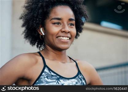 Portrait of afro athletic woman standing outdoors on the street. Sport and healthy lifestyle.