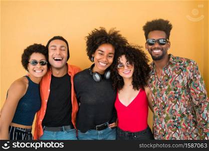Portrait of Afro friends having fun together and enjoying good time against yellow background. Friendship and lifestyle concept.