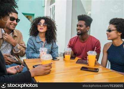 Portrait of Afro friends having fun together and enjoying good time while drinking fresh fruit juice.