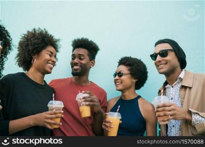 Portrait of afro friends having fun together and enjoying good time while drinking fresh fruit juice.
