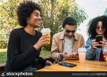 Portrait of Afro friends having fun together and enjoying good time while drinking fresh fruit juice.