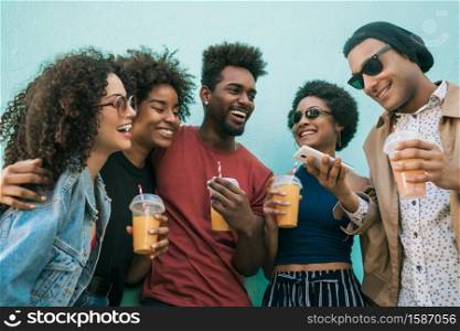 Portrait of afro friends having fun together and enjoying good time while drinking fresh fruit juice.