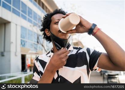 Portrait of afro man drinking a cup of coffee outdoors. Urban and lifestyle concept.