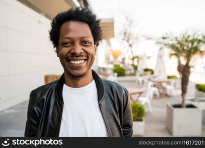 Portrait of afro tourist man standing outdoors on the street. Urban and lifestyle concept.