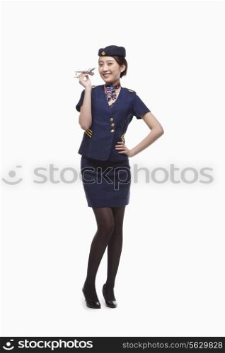 Portrait of Air Stewardess Holding Model Airplane