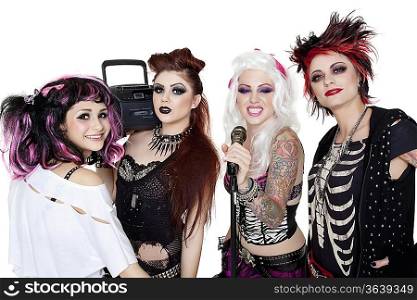 Portrait of all female band with microphone and boom box over white background