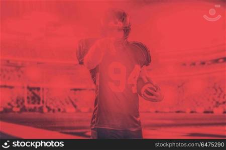 Portrait of American football player pointing against gray background. American football player pointing