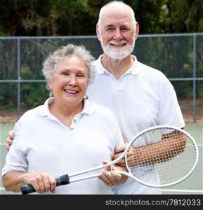 Portrait of an active senior couple on the tennis courts.