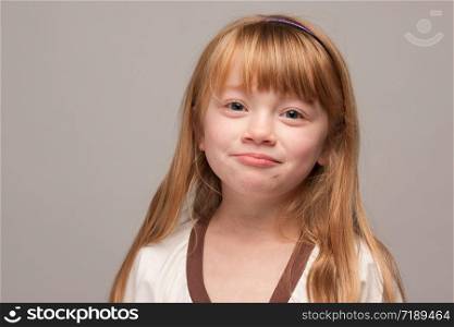 Portrait of an Adorable Red Haired Girl on a Grey Background.