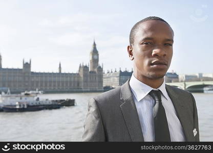 Portrait of an African American businessman standing in front of river