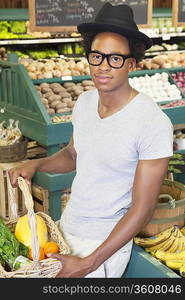 Portrait of an African American man with vegetable basket at supermarket