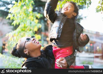 Portrait of an African american mother with his son having some fun outdoors in the park. Monoparental family.