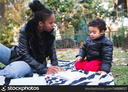 Portrait of an African american mother with his son playing and having fun together outdoors in the park. Monoparental family.