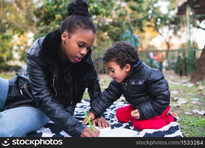 Portrait of an African american mother with his son playing and having fun together outdoors in the park. Monoparental family.