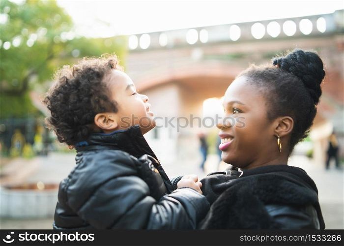 Portrait of an African american mother with his son playing together outdoors in the park and having fun. Monoparental family.