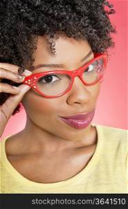 Portrait of an African American woman wearing retro glasses over colored background