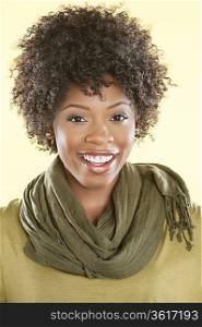 Portrait of an African American woman with a stole round her neck smiling over colored background