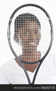 Portrait of an African American young woman looking through tennis racket