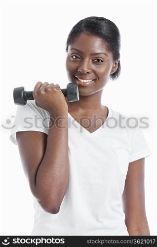 Portrait of an African American young woman with dumbbell over white background