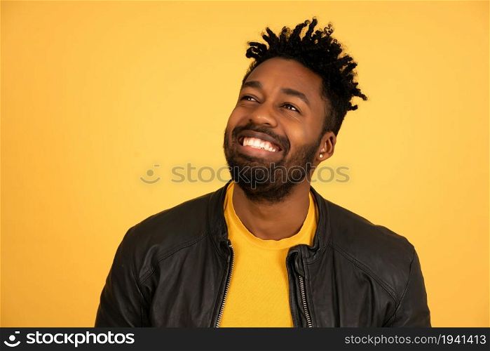 Portrait of an afro man smiling while standing against isolated an isolated background.