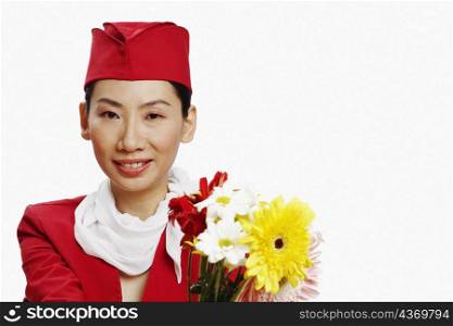 Portrait of an air stewardess holding flowers and smiling