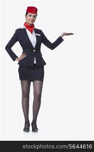 Portrait of an airhostess holding invisible product isolated over white background
