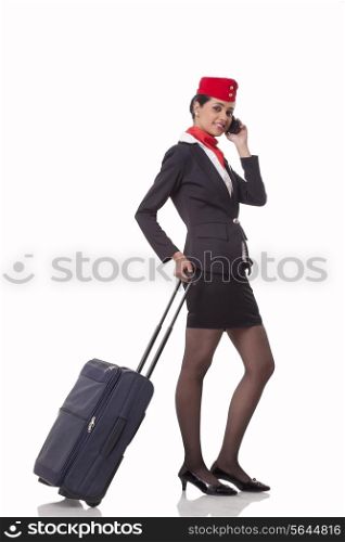 Portrait of an airhostess on call while holding luggage bag&rsquo;s handle isolated over white background