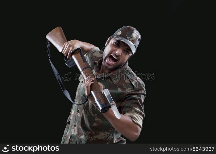 Portrait of an angry young soldier holding gun