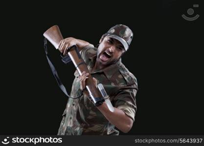 Portrait of an angry young soldier holding gun