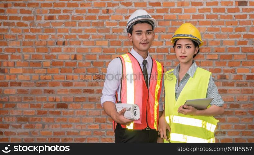 Portrait of an architect builder and woman engineer in front of brick wall with copy space. architect builder and woman engineer