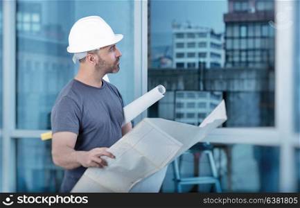 Portrait of an architect builder studying layout plan of the rooms, serious civil engineer working with documents on construction site, building and home renovation, professional foreman at work