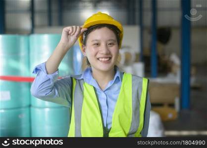 Portrait of An Asian smiling engineering woman is working in modern warehouse