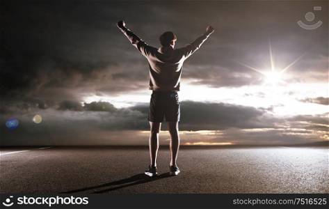 Portrait of an athlete looking at the dark sky