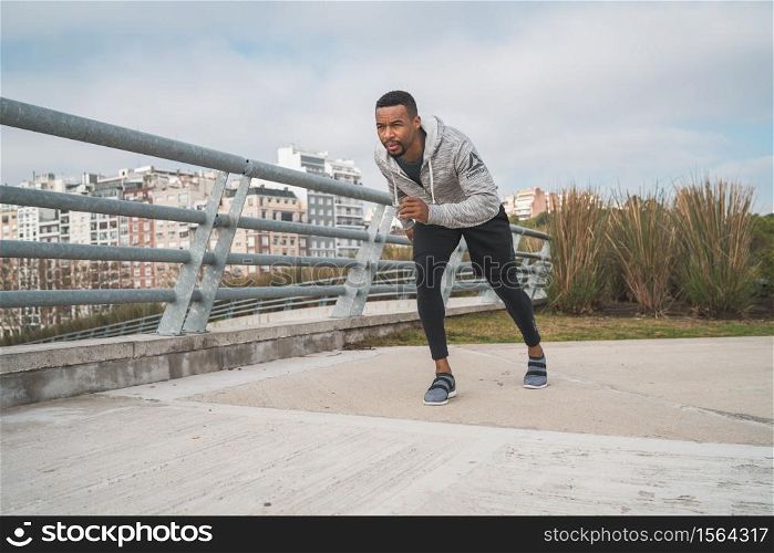 Portrait of an athletic man running outdoors in the street. Sport, fitness and healthy lifestyle.