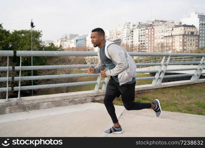 Portrait of an athletic man running outdoors in the street. Sport, fitness and healthy lifestyle.