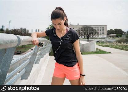 Portrait of an athletic woman listening to music on a break from training. Sport and health lifestyle concept.