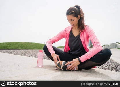 Portrait of an athletic woman on break from training while sitting in park. Sport and health lifestyle.