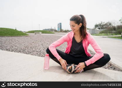 Portrait of an athletic woman on break from training while sitting in park. Sport and health lifestyle.