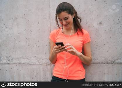 Portrait of an athletic woman using her mobile phone on a break from training. Sport and health lifestyle.