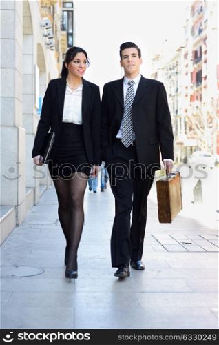 Portrait of an atractive business people walking on the street. Couple working.
