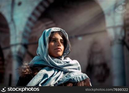 Portrait of an attractive Arabic girl wearing a beautiful traditional scarf to cover her head, gorgeous authentic beauty of women