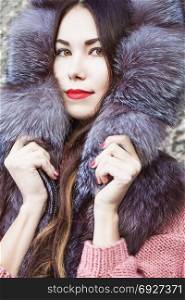 portrait of an attractive asian girl in a fur coat, outdoor