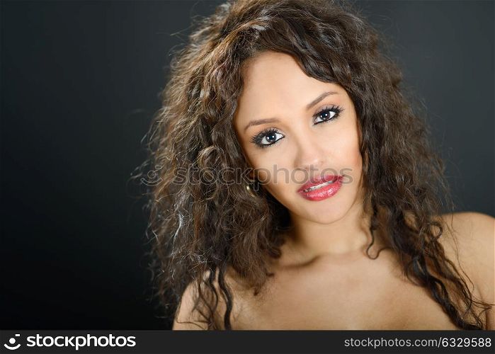 Portrait of an attractive mixed woman on black background
