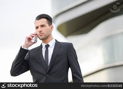 Portrait of an attractive young businessman on the phone in an office building
